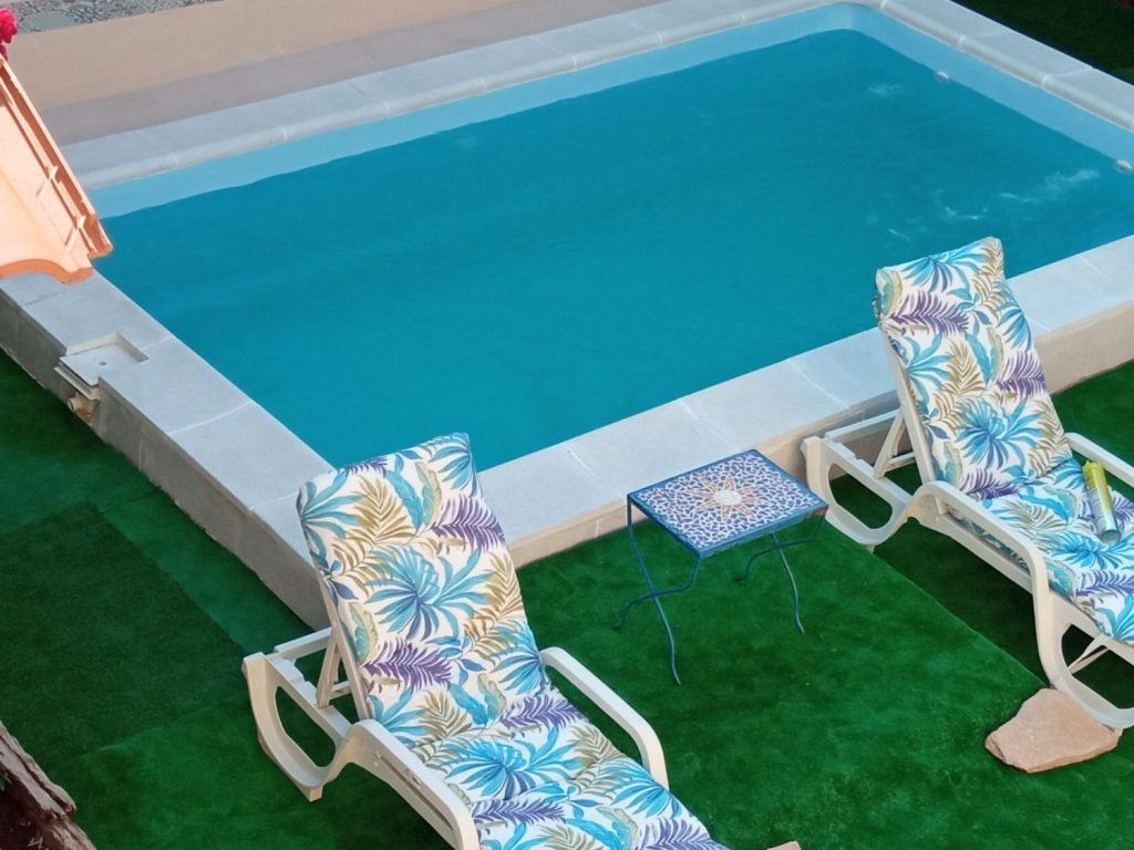 Piscina con tumbonas y mesa